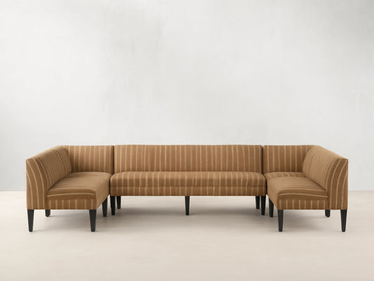 Eaton U-Shaped Banquette in light brown & white striped fabric, U-shaped, with dark tapered legs on a wood floor.