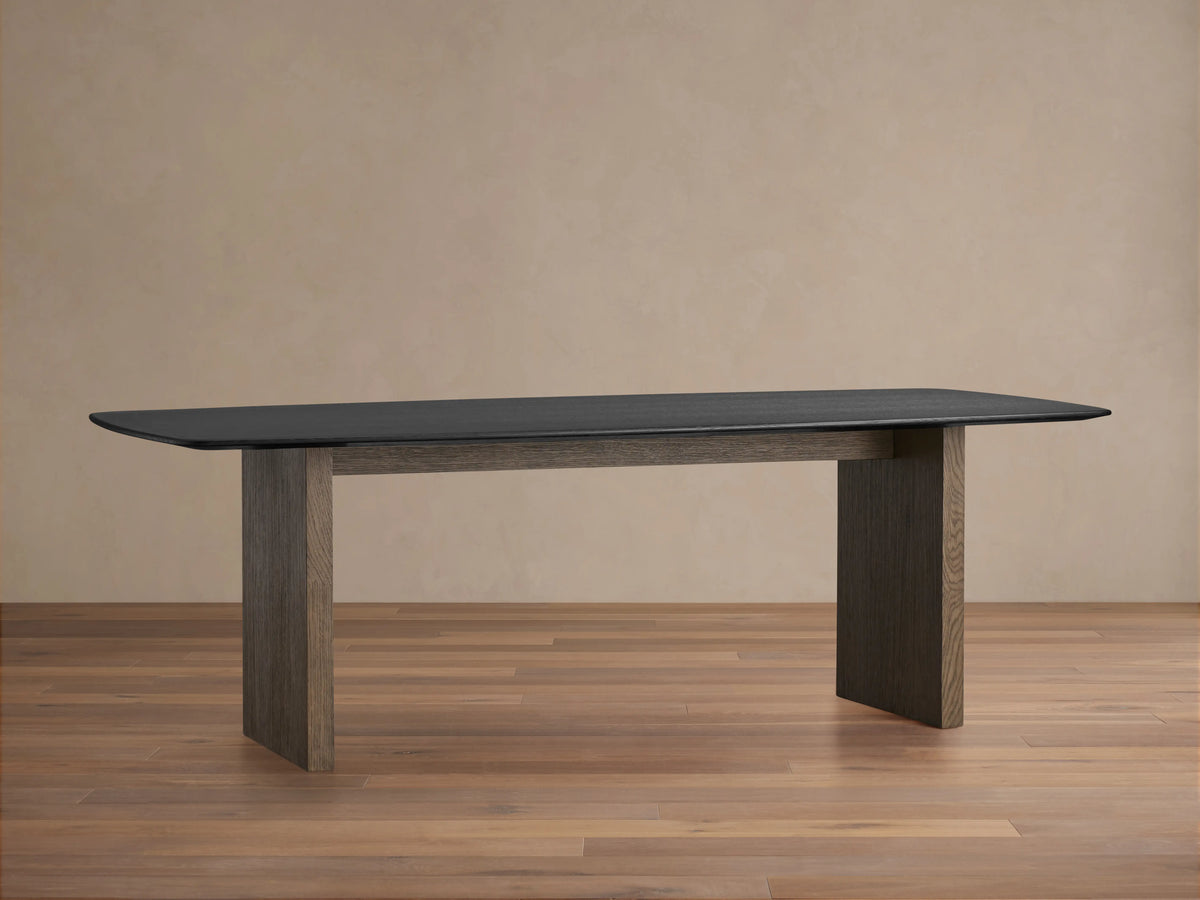 Saint Germain dining table with rectangular dark wood top and sturdy wooden base, placed on a light wooden floor.