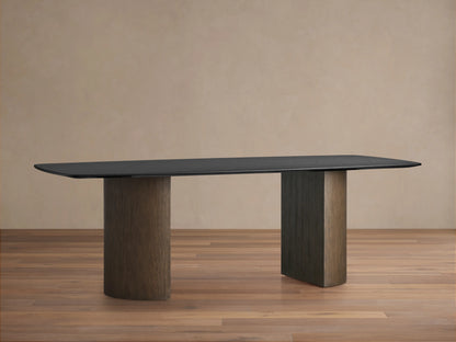 Saint Germain Wood Dining Table with ebony finish, oval top, and dual cylindrical Dauphine bases on a wooden floor.