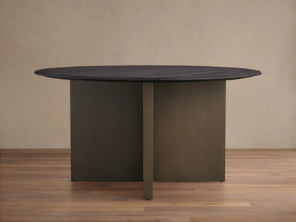 Round Saint Germain dining table with a dark oak tabletop and V-shaped Clement base in a bronze finish, on a wooden floor.