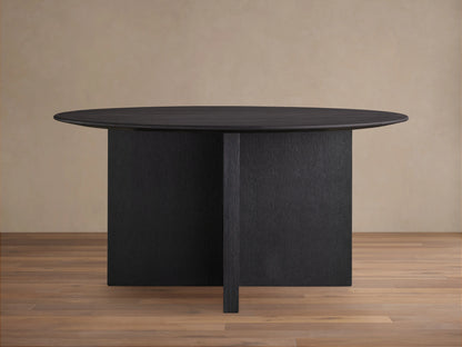 Saint Germain round dining table with an ebony wood top and a sturdy wood base, set on a light wood floor.
