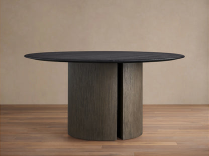 Saint Germain round dining table with a dark solid oak top, set on a sturdy, cylindrical Dauphine base, on a wood floor.