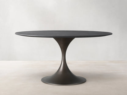 Saint Germain Round Wood Dining Table with ebony-finished oak top and steel Launette base on a wooden floor.