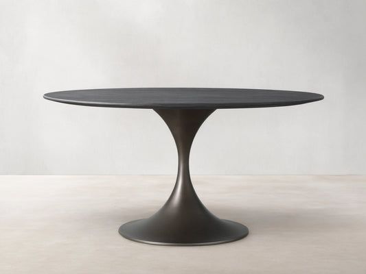 Saint Germain Round Wood Dining Table with ebony-finished oak top and steel Launette base on a wooden floor.