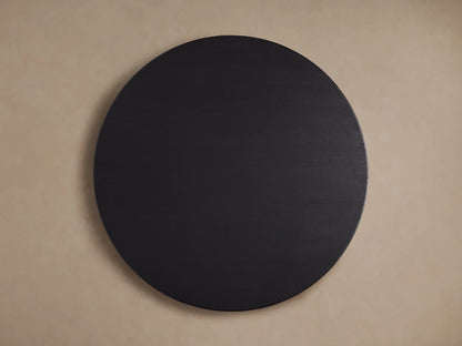 Saint Germain Round Wood Dining Table with an ebony finish. Close-up of the textured oak veneer tabletop against a neutral background.
