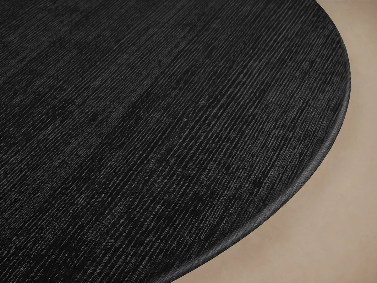 Saint Germain round wood dining table with an ebony finish, featuring a unique Rennes base design, on wooden floor.