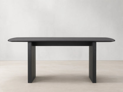 Saint Germain dining table with solid oak top and rectangular base, finished in dark Ebony, on wooden floor.