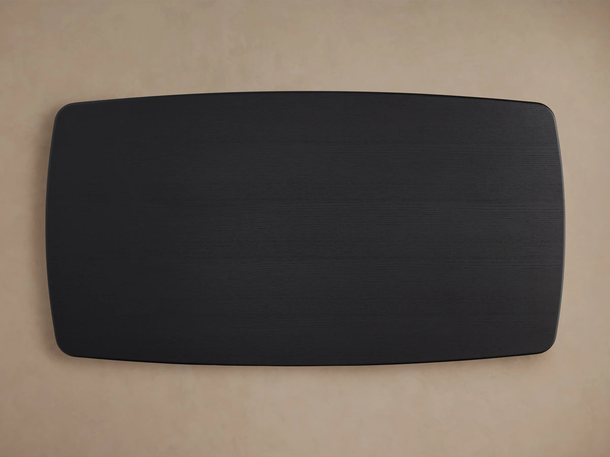 Dark wood tabletop of the Saint Germain Dining Table, featuring a smooth, polished finish and visible oak grain on a beige background.