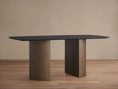 Saint Germain Wood Dining Table with a dark ebony tabletop and two columnar bases in oak, set on a wooden floor.