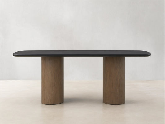 Saint Germain Wood Dining Table with a dark ebony tabletop and two columnar bases in oak, set on a wooden floor.