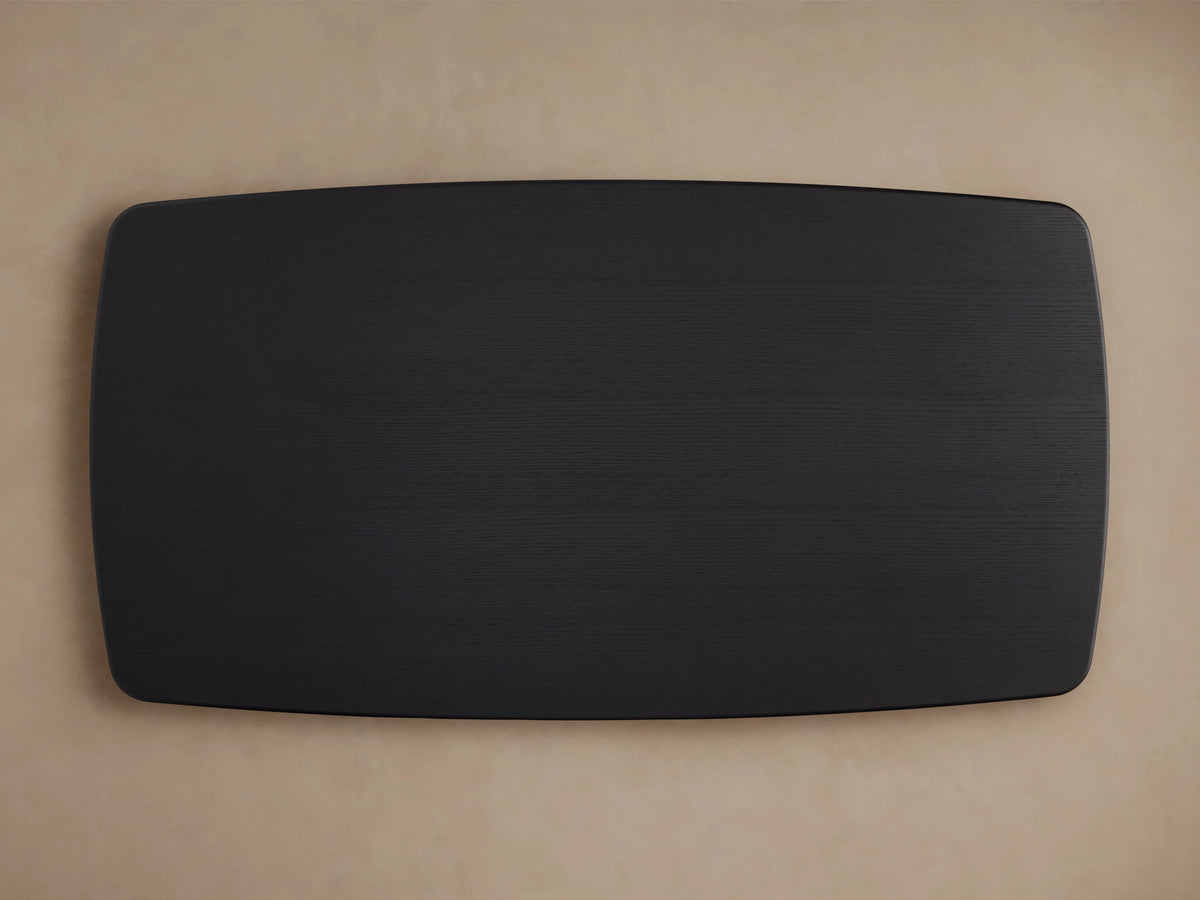 Saint Germain wood dining table with a close-up of the solid oak tabletop in a dark Ebony finish, showing smooth edges.