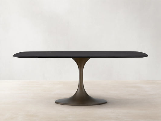 Saint Germain Wood Dining Table with a sleek rectangular top in Ebony finish and a sculpted steel Launette base on wooden flooring.