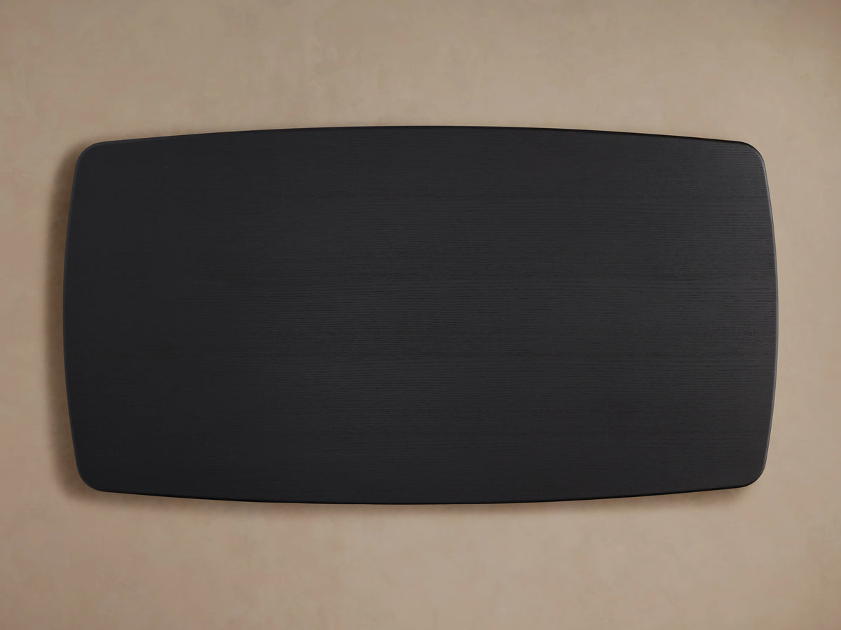 Saint Germain Dining Table corner with smooth, dark ebony finish, highlighting oak grain texture against a neutral background.