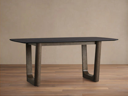 Saint Germain Wood Dining Table with ebony top and chestnut finish base on wood floor, shown against beige wall.