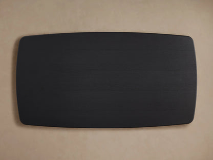 Saint Germain Wood Dining Table's corner with ebony finish, showing smooth texture and oak veneer grain against a beige background.