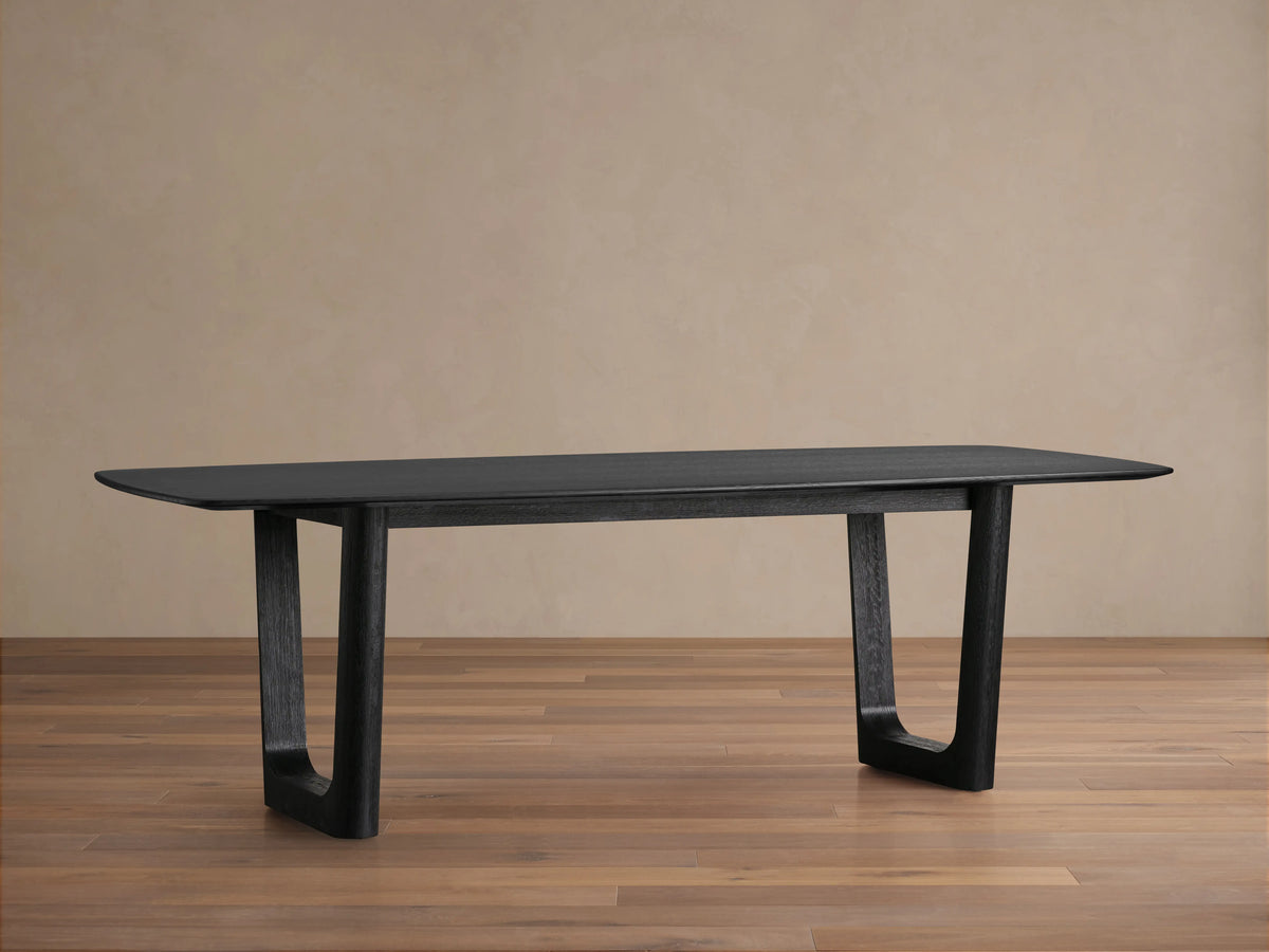 Saint Germain Wood Dining Table with an ebony finish, featuring a rectangular top and solid oak Rennes base on a wooden floor.