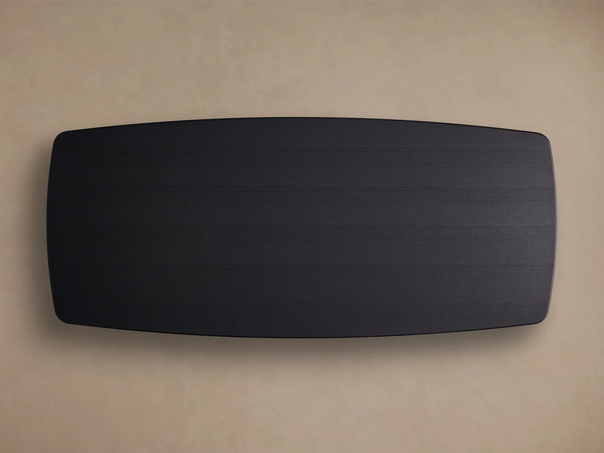 Edge view of the Saint Germain Wood Dining Table with an Ebony finish, showcasing the smooth oak veneer surface and rounded corner.