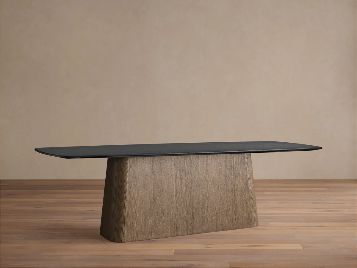 Saint Germain dining table with dark ebony top & light oak Toulouse base on a wooden floor.