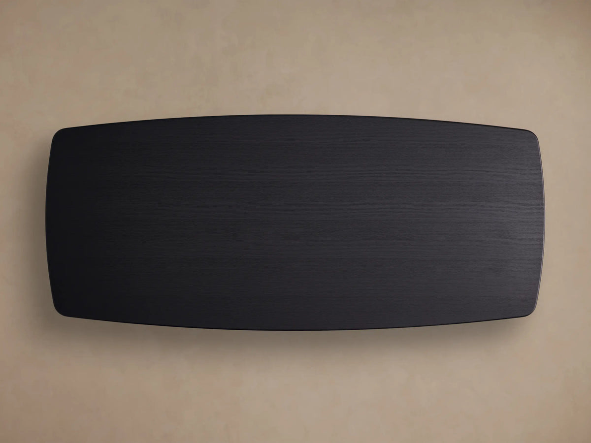 Close-up of Saint Germain Wood Dining Table's black ebony finish tabletop, showing wood grain and a rounded corner.