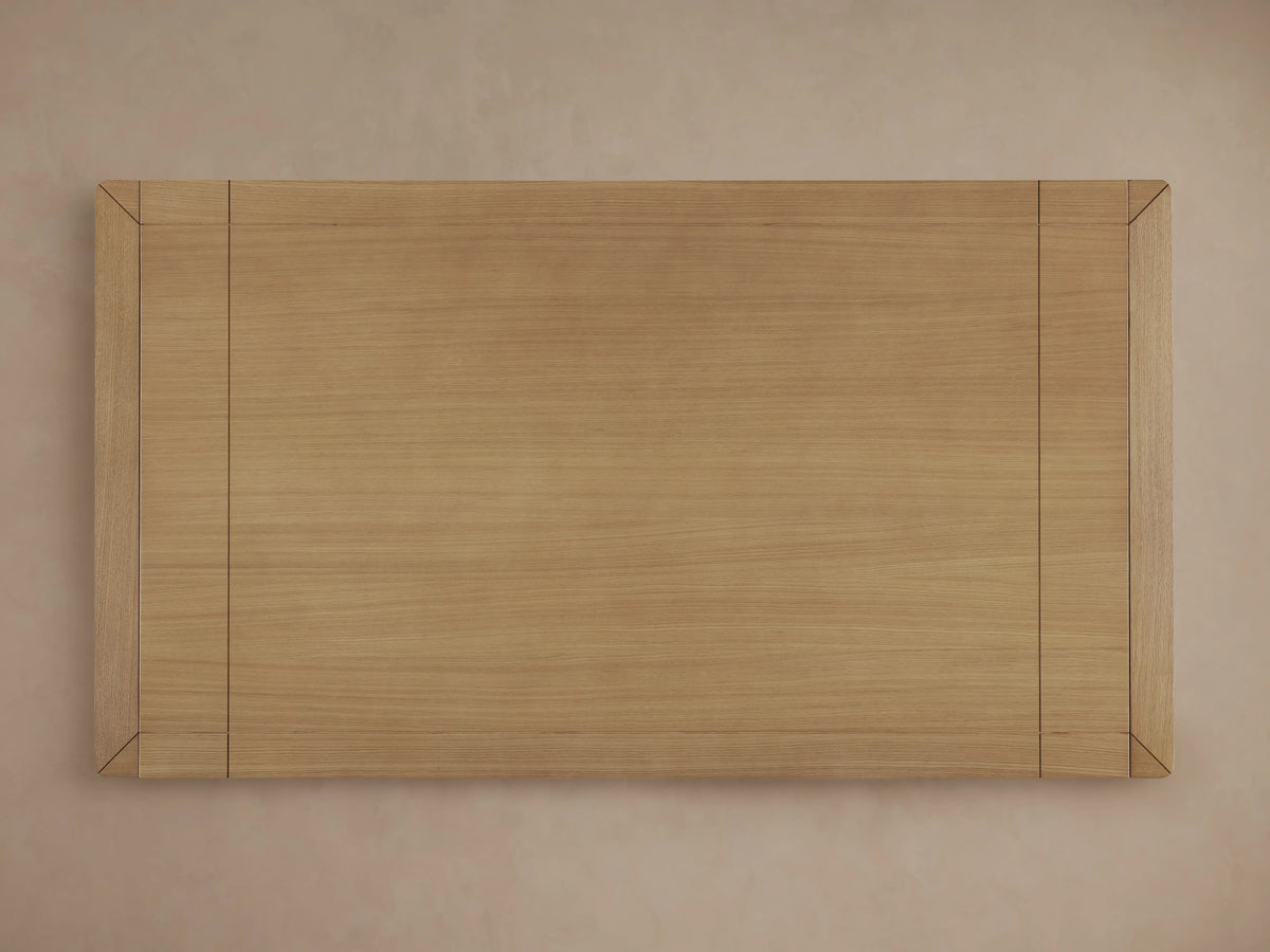 Close-up of Eletta Dining Table corner in light European white oak wood, showing rounded edge, wood grain, and tabletop joint.