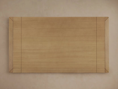 Close-up of Eletta Dining Table corner in light European white oak wood, showing rounded edge, wood grain, and tabletop joint.