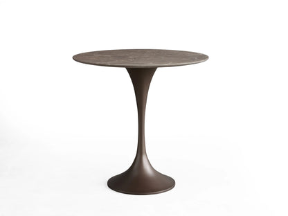 Round tabletop made of black marquina marble featuring white veining, viewed from above against a beige background.