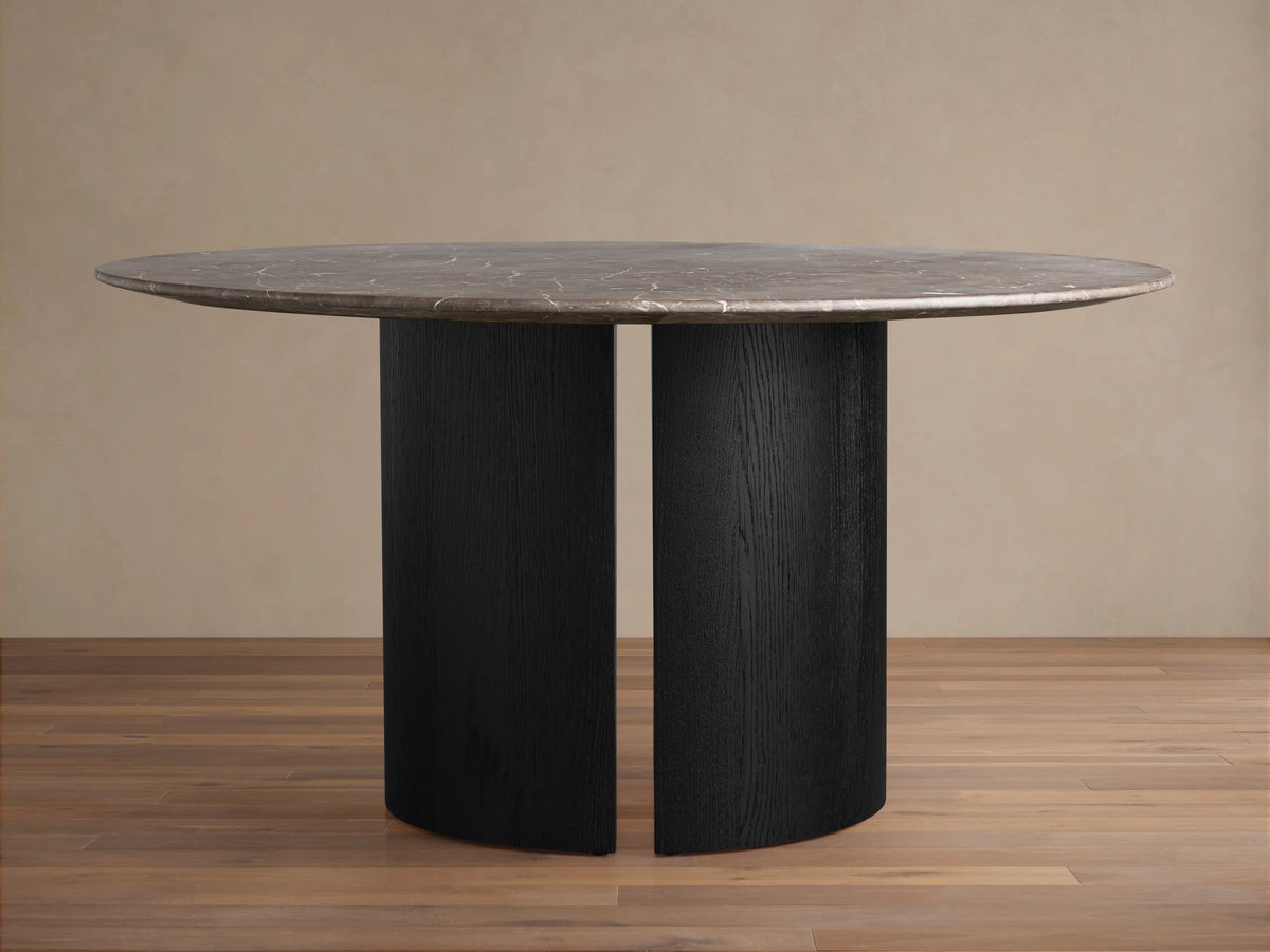 Saint Germain Round Stone Dining Table features a dark gray round stone top on a black Dauphine base with visible wood grain.