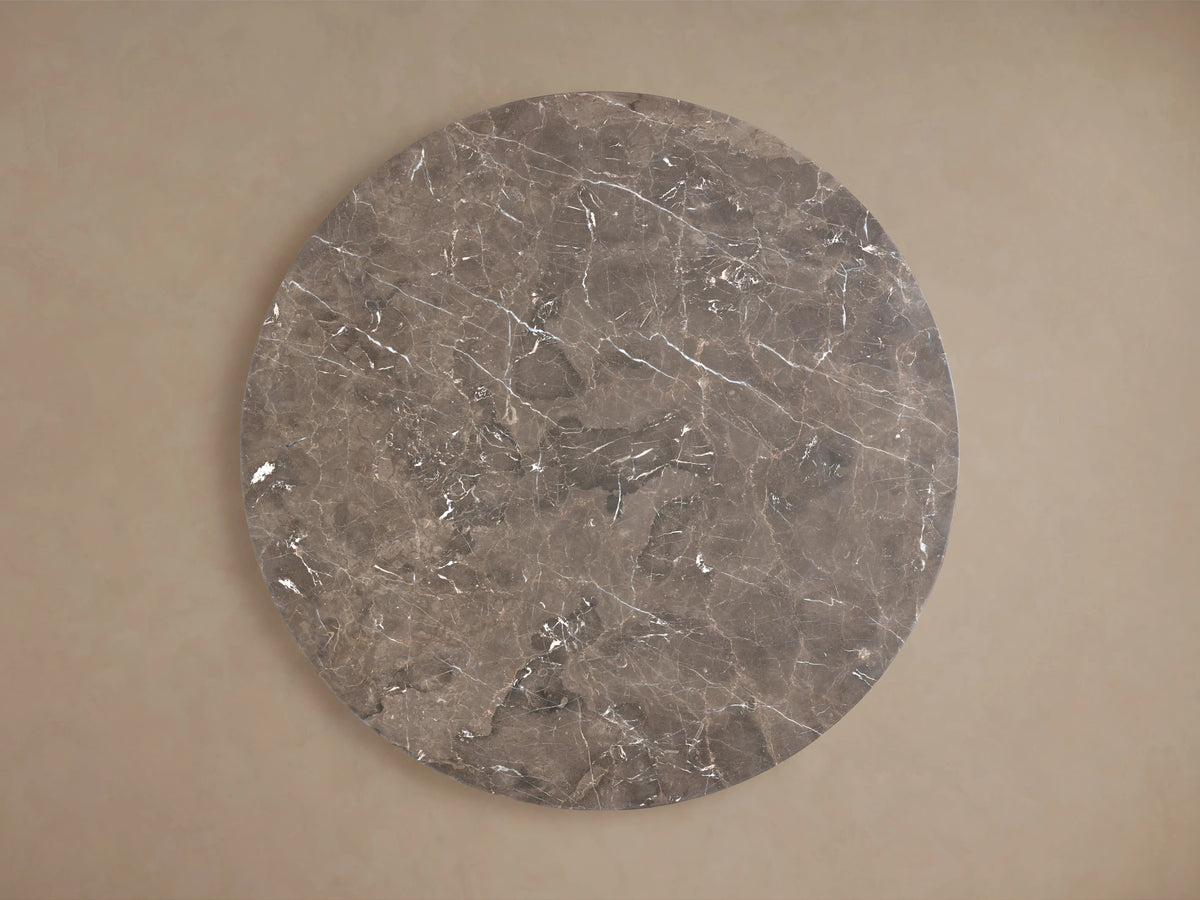 Close-up of the Saint Germain Round Stone Dining Table's dark brown marble top with prominent white and reddish-brown veining.