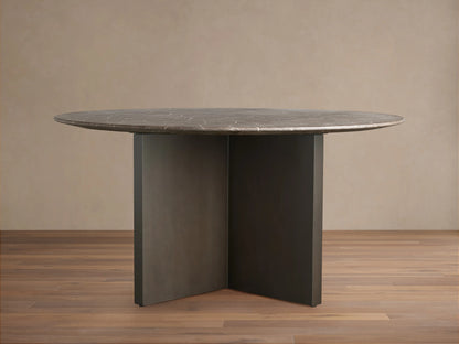 Saint Germain Round Stone Dining Table with a dark stone top and two-tone Clement base on a wooden floor.