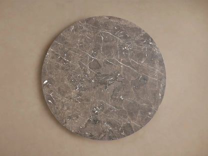 Round tabletop of the Saint Germain Dining Table made from espresso brown stone. Visible natural veining and mineral deposits create unique patterns.
