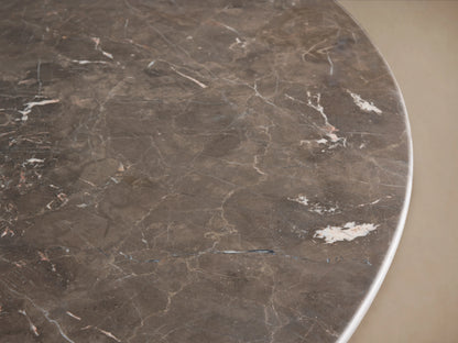 Saint Germain Round Stone Dining Table with mottled dark stone top and two curved ebony wood Dauphine base panels.
