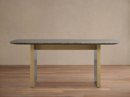 Stone dining table with an espresso brown top showing natural veining, supported by a brass-finished steel base, on a wooden floor.
