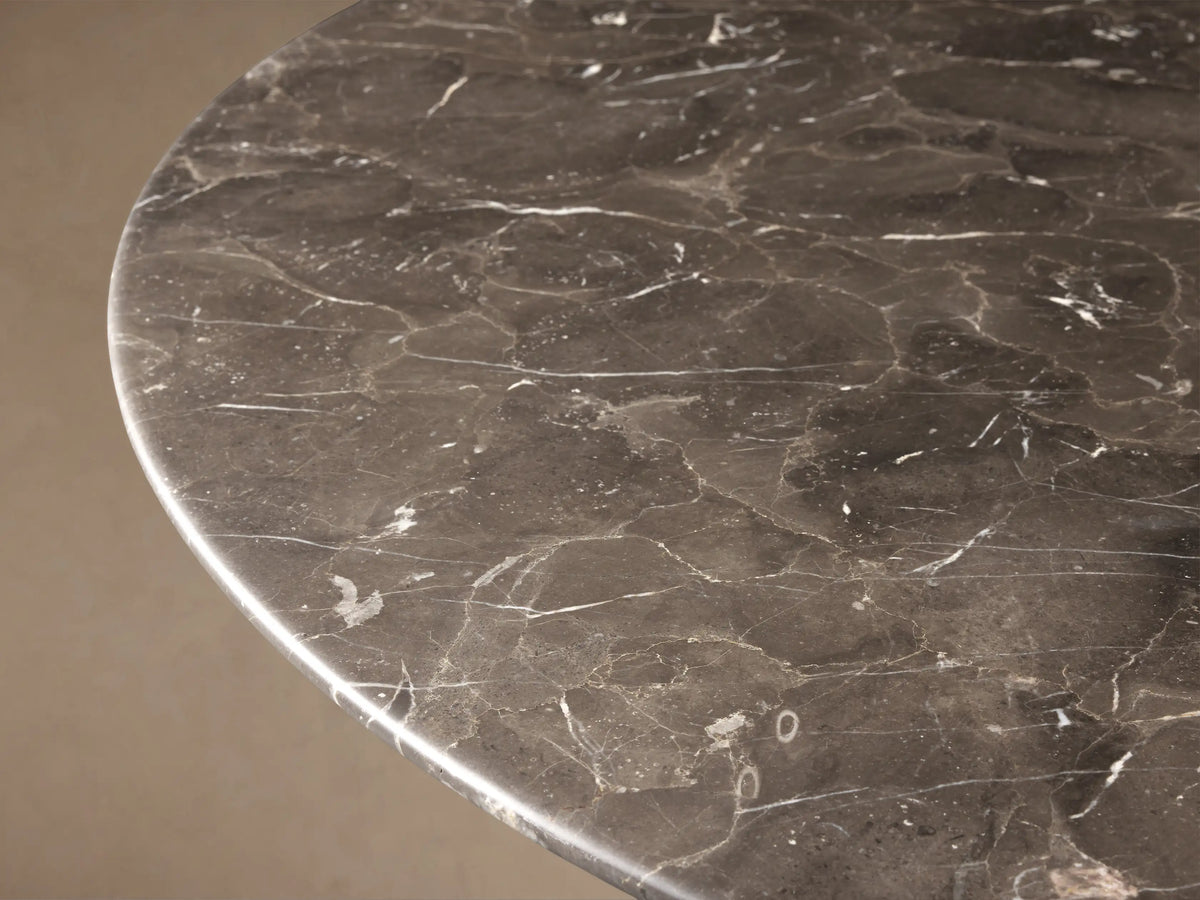 Saint Germain Round Stone Dining Table: espresso brown marble top, black wooden conical Toulouse base on wood floor.