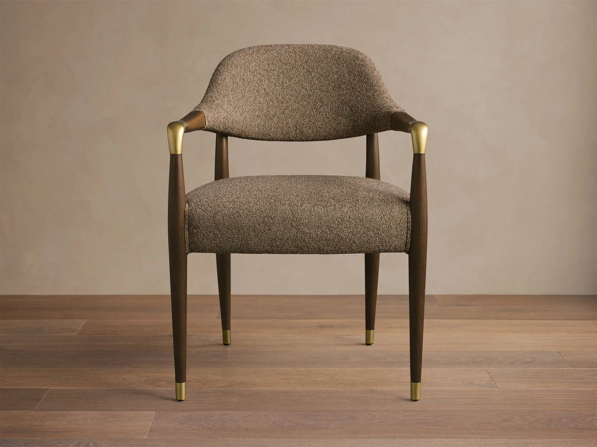 Front view of the Evelyn Dining Arm Chair with brown tweed upholstered seat, dark mahogany frame, and brushed brass accents.