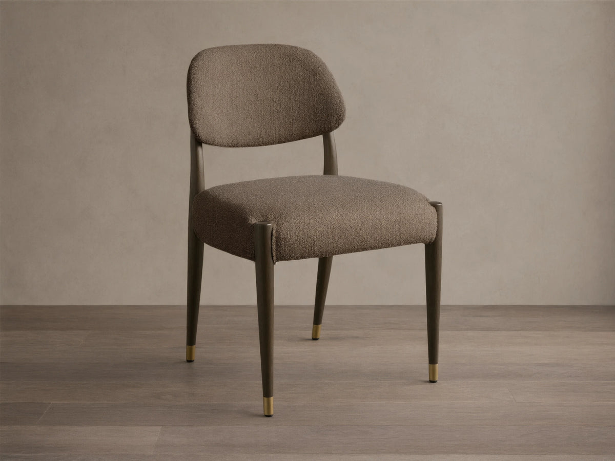 Front-quarter view of the Evelyn Dining Side Chair with textured brown upholstery, dark mahogany legs, and brushed brass accents.