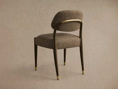 Rear view of the Evelyn Dining Side Chair with textured brown upholstery, dark wood frame, a curved brass back accent, and brass leg caps.