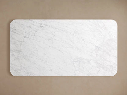 Finnley Dining Table with a rectangular Carrara marble top, white with gray veining, against a neutral background.