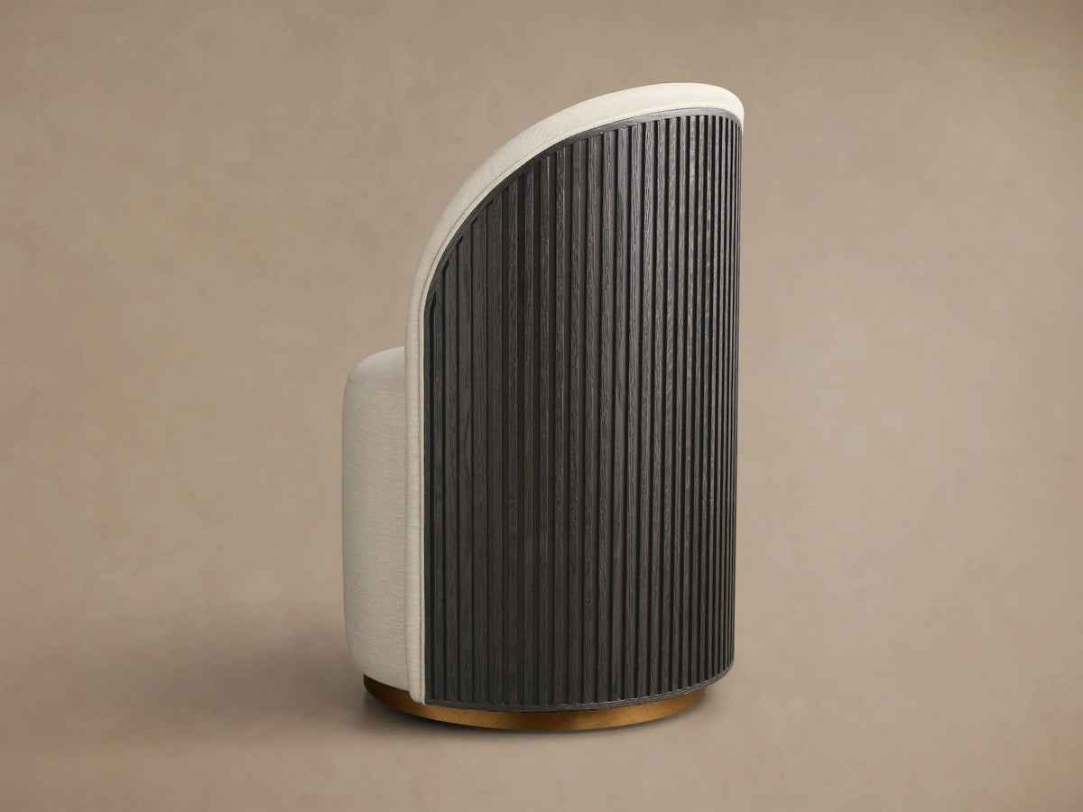 Side view of the Finnley Dining Side Chair, featuring a curved reeded Ebony back, cream upholstery, and brass plinth base.