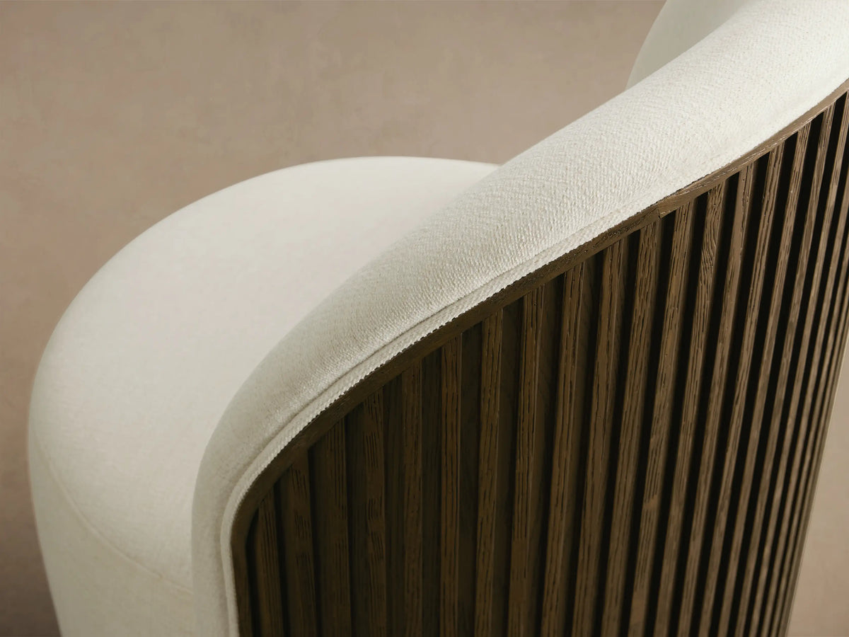 Close-up of the Finnley Dining Side Chair, showing its curved back with cream upholstery and dark reeded wood veneer.