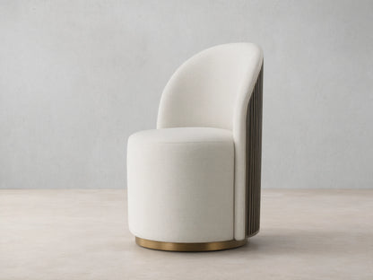 Cream Finnley Dining Side Chair, front-facing, with a curved back, dark reeded wood paneling, and a brass plinth base.