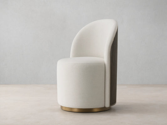 Cream Finnley Dining Side Chair, front-facing, with a curved back, dark reeded wood paneling, and a brass plinth base.