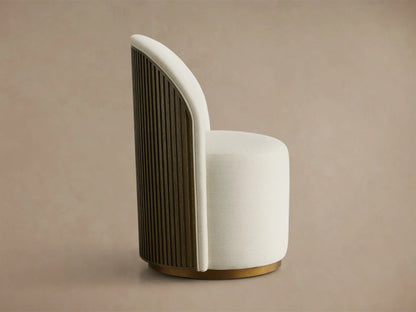 Side profile of a Finnley Dining Side Chair with cream upholstery, a curved Mocha reeded wood back, and a brass plinth base.