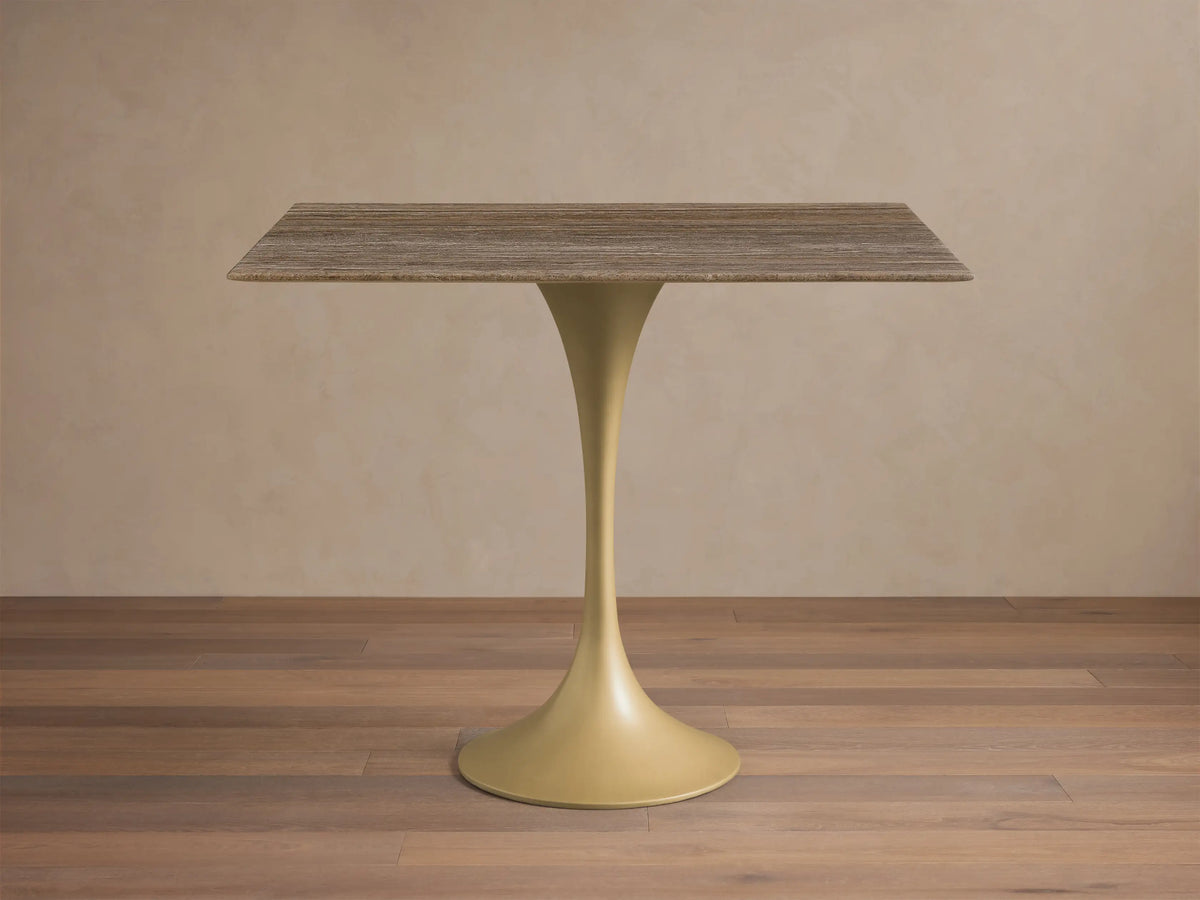 Front view of the rectangular Saint Germain Bistro Table with a striated grey-brown stone top and a flared sandy yellow metal base.