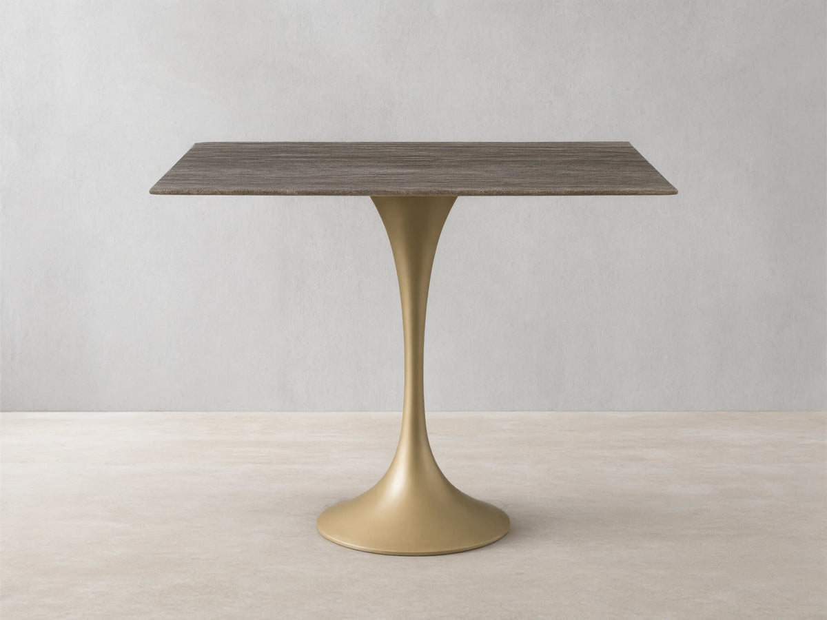 Front view of the rectangular Saint Germain Bistro Table with a striated grey-brown stone top and a flared sandy yellow metal base.