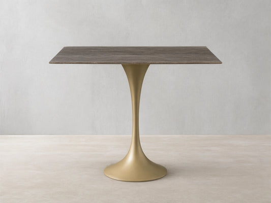 Front view of the rectangular Saint Germain Bistro Table with a striated grey-brown stone top and a flared sandy yellow metal base.