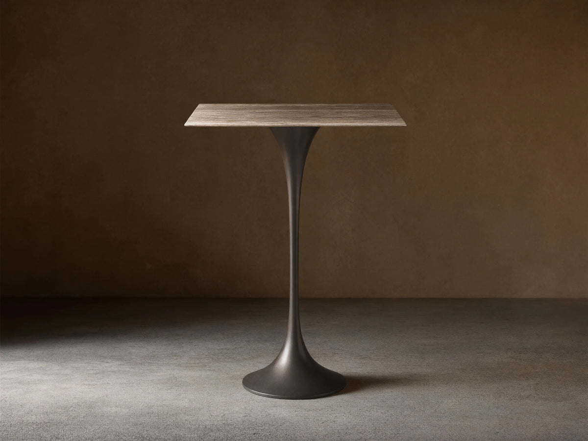 Front view of the Saint Germain Square Bar Table with a light woodgrain square top and a dark tapered pedestal base.