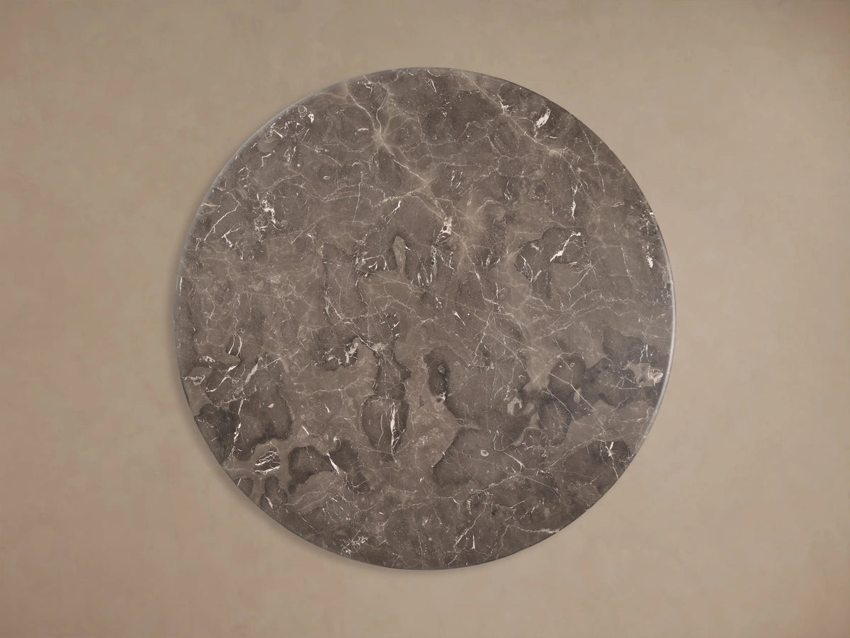 Front view of the Dark grey marble Gabriella Round Stone Dining Table with sculptural fin-style supports and hexagonal base.