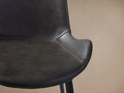 Gage Faux Leather Dining Chair: dark grey, front view, baseball stitching, black iron legs, on wood floor.
