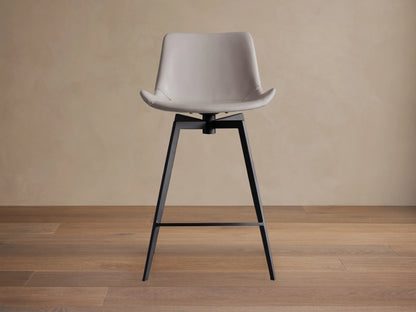 Gage Faux Leather Swivel Counter Stool, grey faux leather seat with baseball stitching, black iron legs, side view.