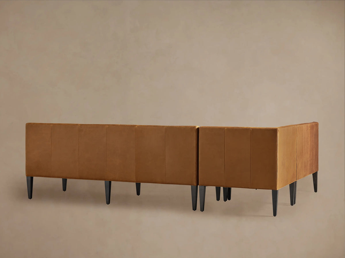 Close-up of a Gates Leather Banquette; rich tan recycled leather with vertical channel-stitched backrest, smooth seat.